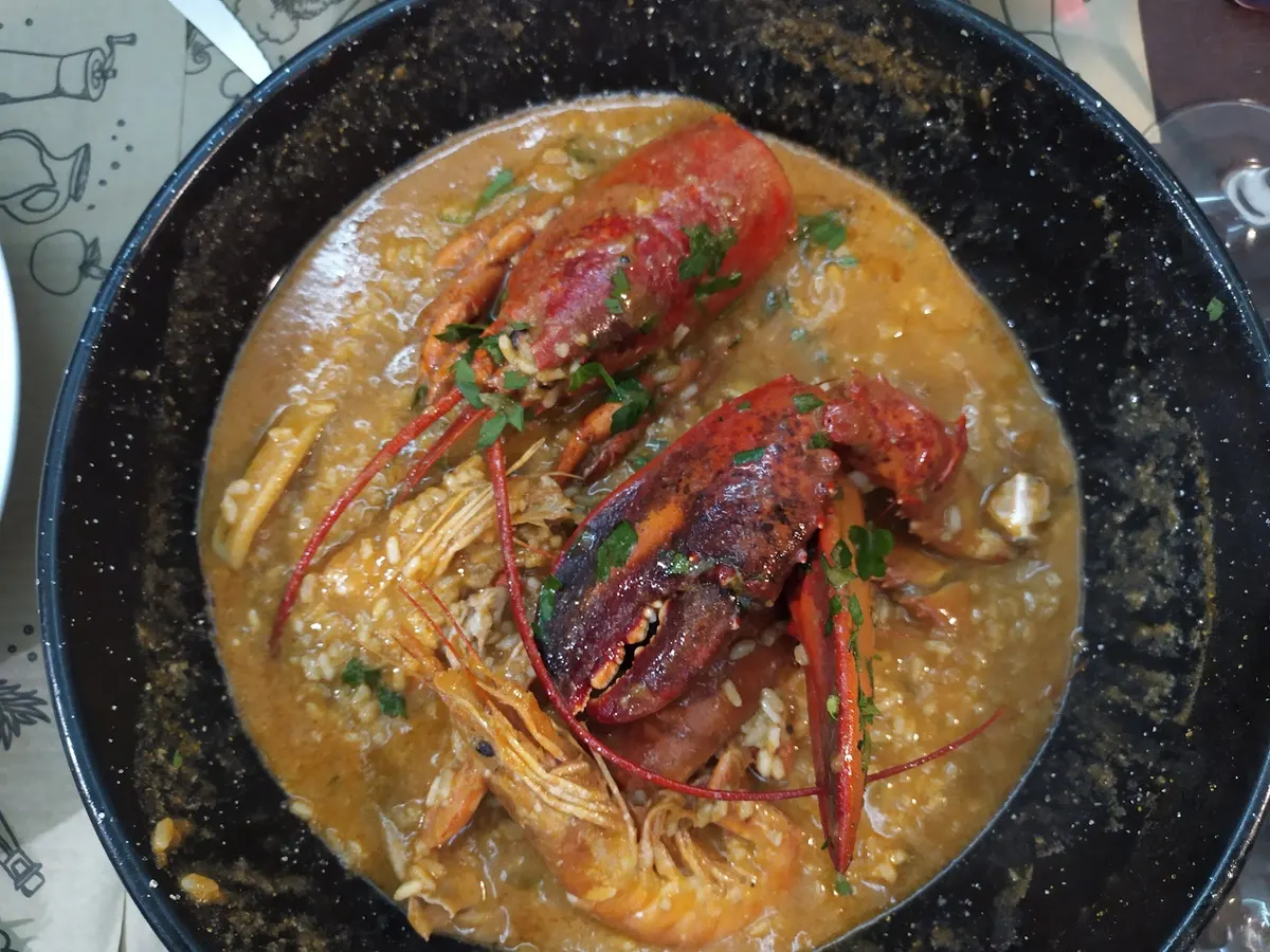 Arroz meloso con bogavante y langostinos en su paellera, visto desde arriba
